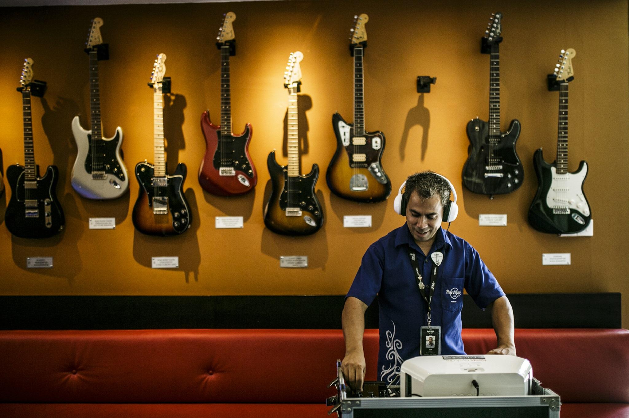Hard Rock Hotel Penang Batu Feringgi Exterior foto A guitar store employee listens to a customer's selection